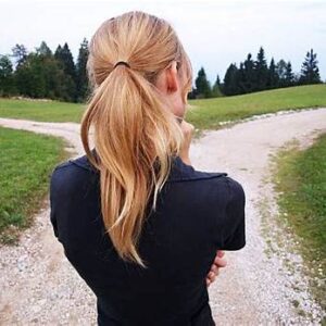 woman standing at a crossroads, unsure which path to take - symbolizing lack of self-trust.
